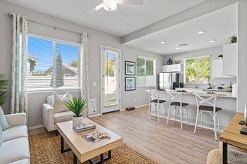 an open living room and kitchen with a dining table and chairs